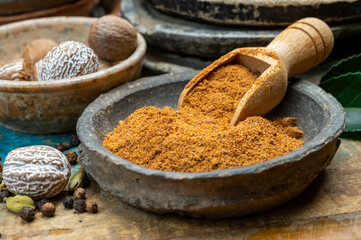Nutmeg powder. Macro view whole nuts and grated muscat nuts on vintage background.