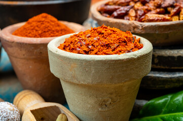 Colorful ground spicy chili peppers , pimento and curcuma is clay pots close up