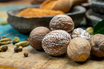 Nutmeg powder. Macro view whole nuts and grated muscat nuts on vintage background.