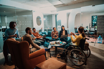 Businesswoman in wheelchair having business meeting with team at modern office. A group of young freelancers agree on new online business projects - obrazy, fototapety, plakaty