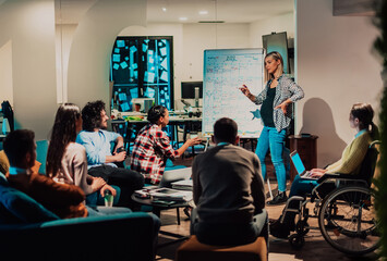  A pregnant businesswoman leads a creative meeting of a diverse business team in a modern coworking