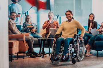 Fototapeta na wymiar Businesswoman in wheelchair having business meeting with team at modern office. A group of young freelancers agree on new online business projects