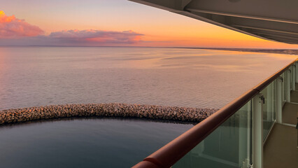 Sunset over the sea from a cruise ship cabin balcony