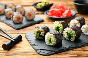 Tasty sushi rolls served on wooden table