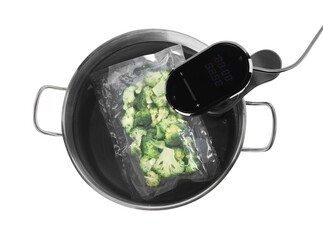 Thermal immersion circulator and vacuum packed broccoli in pot on white background, top view. Sous...