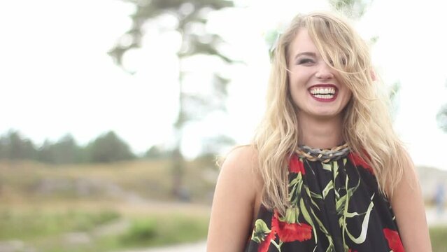 Attractive woman wearing a flower in her hair laughing and dancing