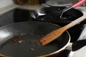 Frying pan with spatula and used cooking oil on stove, closeup