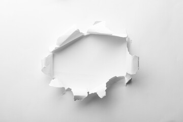 Hole in white paper on light background