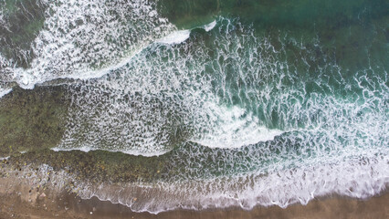 Fototapeta na wymiar Aerial View Of Ocean Waves Crashing On Beach