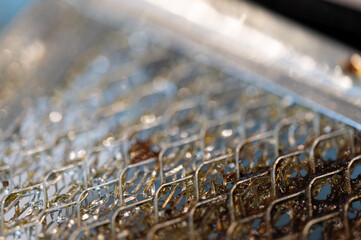 Fototapeta premium Selective focus macro of a dirty kitchen range hood filter clogged with grease.