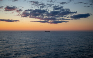 A lone ship in the distance during a sunset