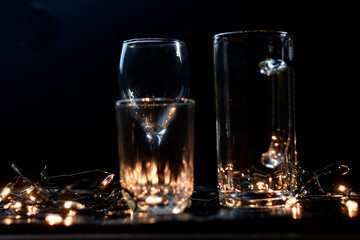 Three empty drink glasses with New Year's lights