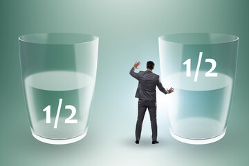 Businessman in half empty half full glass concept