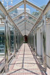 The Tiled corridor under a glass roof of a modern building with abstract design in Thailand.