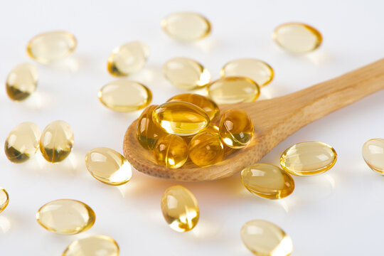 Vitamin E. Supplementary food. Omega 3. Gold fish oil gel Capsules isolated on white background.