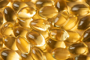Vitamin E Supplementary food. Omega 3. Gold fish oil gel Capsules background.