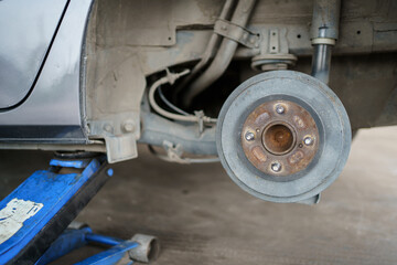 Technician or repairman using a hydraulic jack lift up a car at rear wheel to changing a flat tyre.