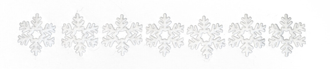 Row of small white felt snowflakes, celebrating winter holidays
