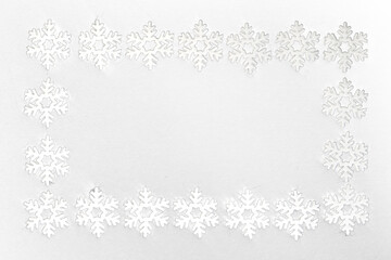 Frame of small white felt snowflakes, celebrating winter holidays
