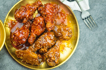 Deep-fried chicken wings or barbecue sprinkled with sesame. Spicy Korean-style fried chicken. Top view