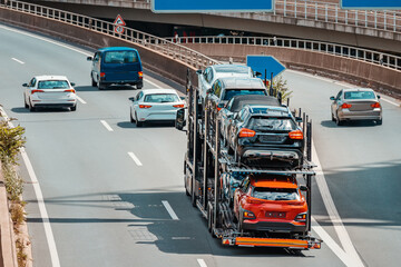 Aerial photo of a truck carrier or transporter with cars as cargo. Automobile shipment and heavy delivery concept