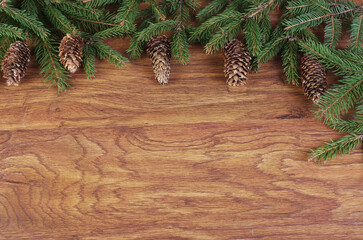 Christmas decorations from fir branches, cones and balls on a wooden texture background. Copy space.