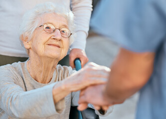 Holding hands, caregiver and senior woman in wheelchair for support outdoor in retirement home....