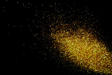 Fototapeta na wymiar Gold glitter powder sparkling on black background.texture christmas