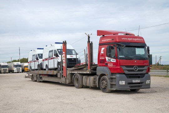 VOLGOGRAD REGION, RUSSIA - SEPTEMBER 18, 2021: Mercedes-Benz Axor car transporter with two new ambulances in the parking lot