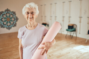 Yoga, mat and portrait of a senior woman in a wellness studio for an exercise or meditation class. Happy, smile and elderly female in retirement at mind and body pilates workout for peace and balance