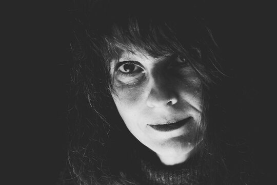 Natürlich schönes Schwarz-Weiß Close-Up Porträt einer Frau 50plus, mit verschmitzter mimik und  mit direkten blick in die Kamera