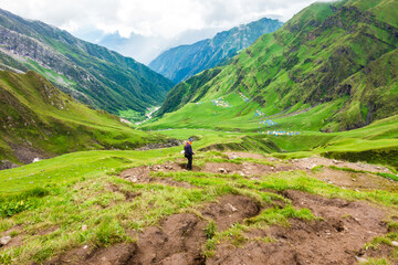 July 14th 2022, Himachal Pradesh India. A man with a walking stick trekking down to Parvati bagh valley during Shrikhand Mahadev Kailash Yatra in the Himalayas.