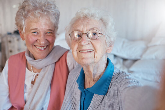 Senior women, friends and selfie with a smile, happiness and care during a visit or lifestyle in a nursing home together. Face portrait of old people happy about retirement, support and trust
