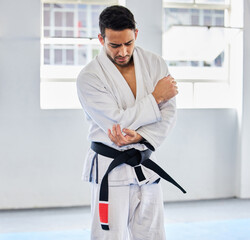Karate, arm pain and man with injury in dojo, healthcare and fighting. Sports, fitness and martial...