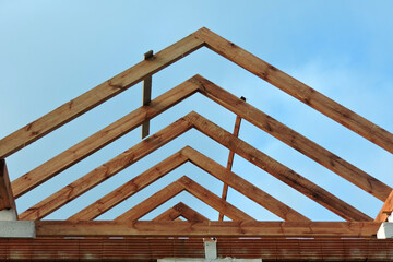 A timber roof truss in a house under construction, walls made of autoclaved aerated concrete...