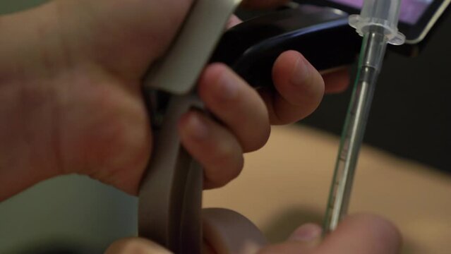 Male doctor puts a tube into the larynx of a manikin using a Video Laryngoscope. Teaching respiratory intubation in the clinic