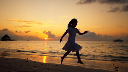 Fototapeta na wymiar Fun Beach Travel Vacation. Kid Running In Sunset