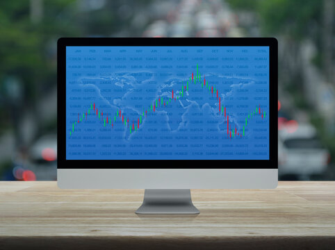 Trading graph of stock market with world map and graph on computer screen on table over blur of rush hour road, Business investment online concept, Elements of this image furnished by NASA