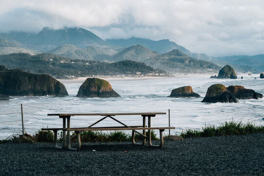 bench at Enola State Park, Cannon Beach heystack rock reflects on the beach in oregon
