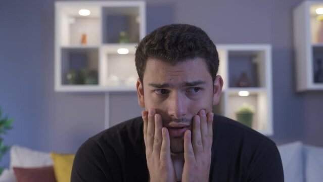 Man with dark phobia is restless at home.
Afraid of the dark, the young man is restless at home.
