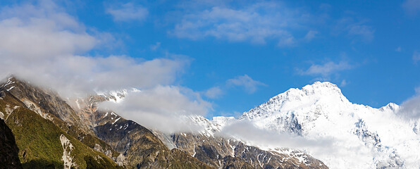 The mountain view of  alpine as snow-capped mount peaks in  Swiss Mountain alps against the blue sky background