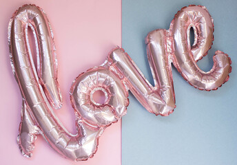 a pink love balloon lies on a combined gray pink background, top view, valentine's day concept