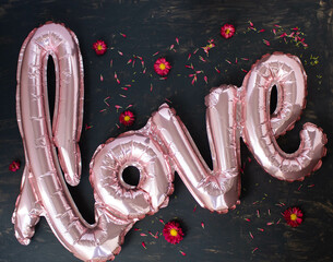 pink love balloon lies on a dark background, top view, valentine's day concept