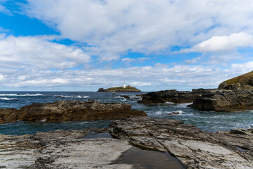 rocky Cornwall coast with the Godrevy Lighthouse behind