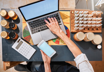 Hands, laptop and honey with a retail woman checking her phone while working at a desk in her...