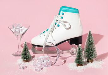 Christmas and New Year creative layout with skate, martini cocktail glasses ,christmas trees, ice cubes and snow on pastel pink background. Winter creative idea. 80s or 90s retro aesthetic concept.
