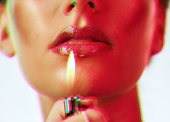 Makeup, beauty and woman with mouth lighter flame for an edgy, gen z and futuristic cosmetic campaign. Neon hologram face effect on shiny lip gloss cosmetics model zoom in white studio. - obrazy, fototapety, plakaty