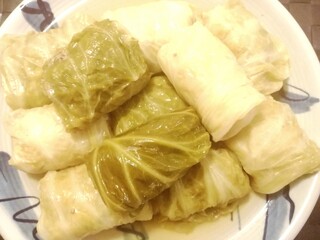 hand holding a tray of fresh baked potatoes　ロールキャベツ