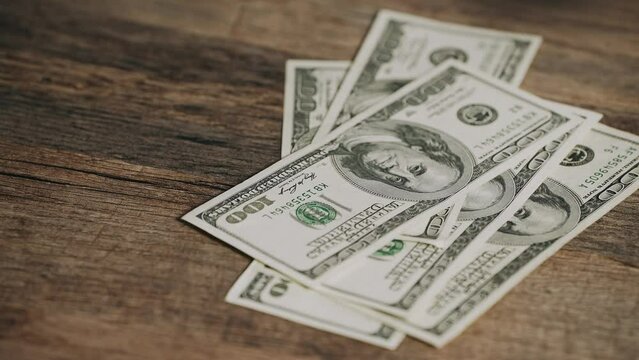 Counting money. Payroll. A stack of $100 bills on a wooden table. Concept of corruption, bribery, finance. Cash American dollars. currency, making money, business  industry,  home finance, cash flow,