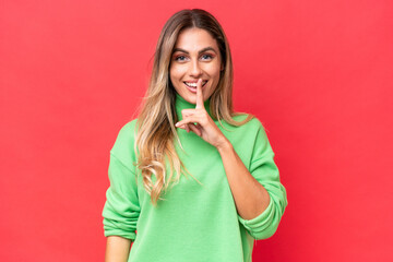 Young Uruguayan woman isolated on red background showing a sign of silence gesture putting finger in mouth